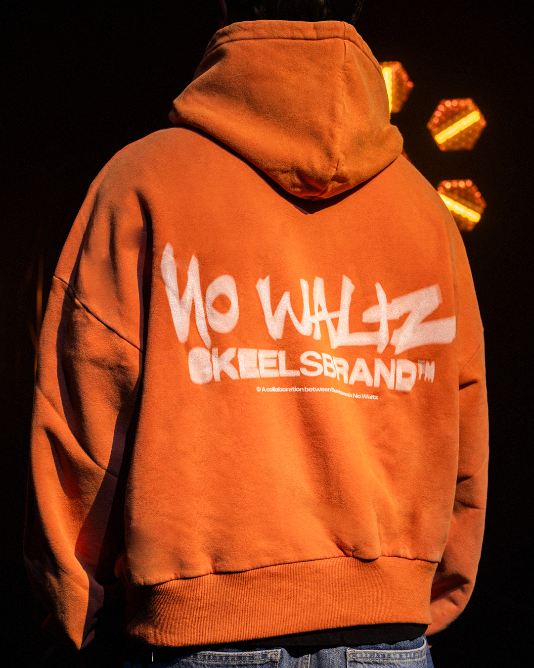 Detalle espalda hoodie naranja con grafismo